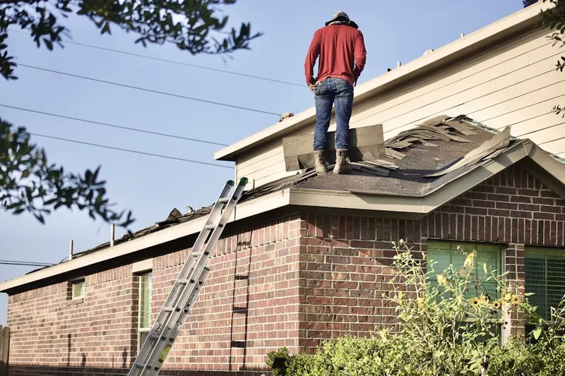 Professional roofer working on a residential roof in Highland Village